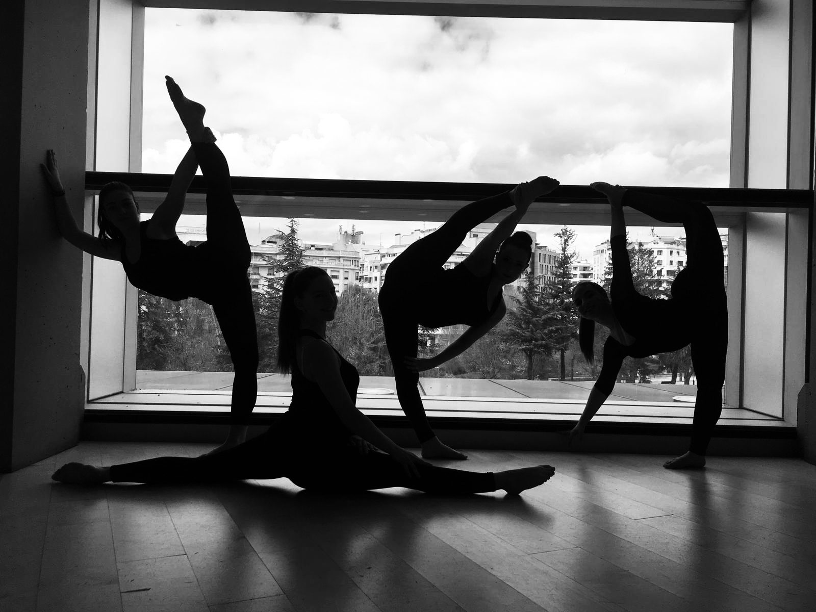 Tres alumnes de dansa a contrallum davant la finestra de la sala